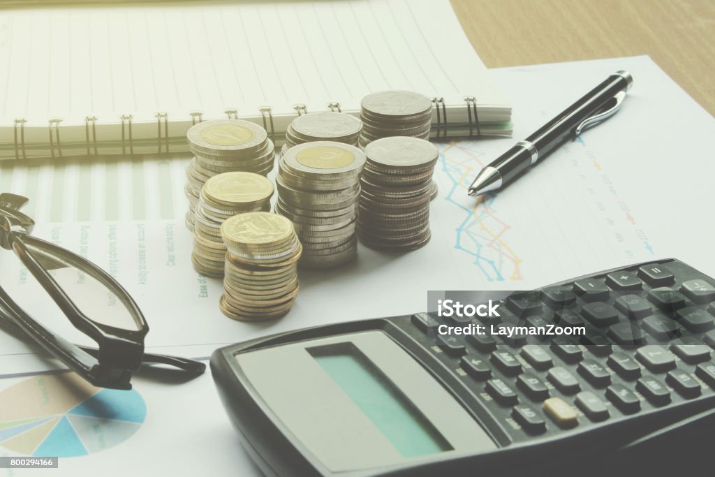 Calculator and Coins of thailand on the office desk investment and property for concept Calculator and Coins of thailand on the office desk investment and property for concept. Abundance Stock Photo