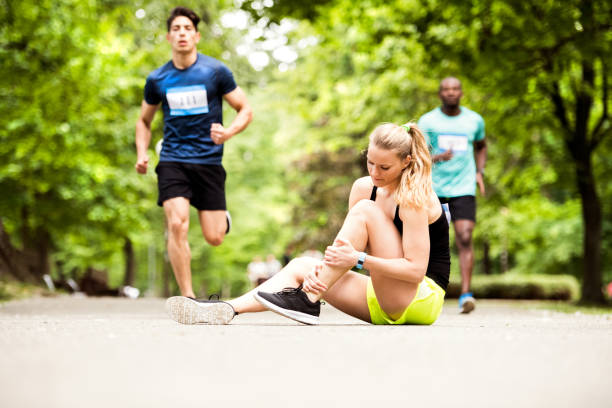 young woman at the competition with sprained ankle. - sprain imagens e fotografias de stock