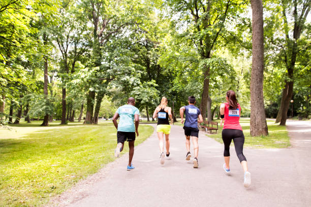 istock Group of young athletes running in green sunny park. 800299878