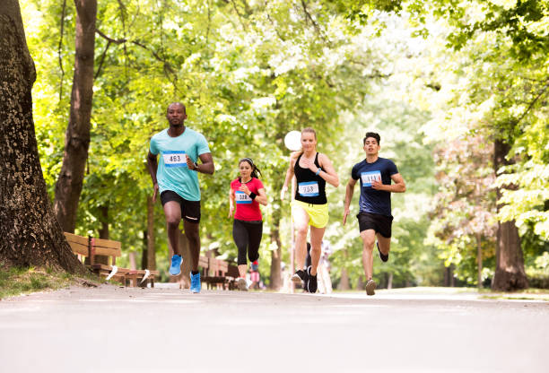 istock Group of young athletes running in green sunny park. 800300014