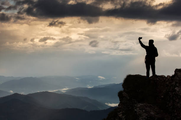 istock Trekker taking selfie on a mountain with beautiful storm clouds in background 800306612