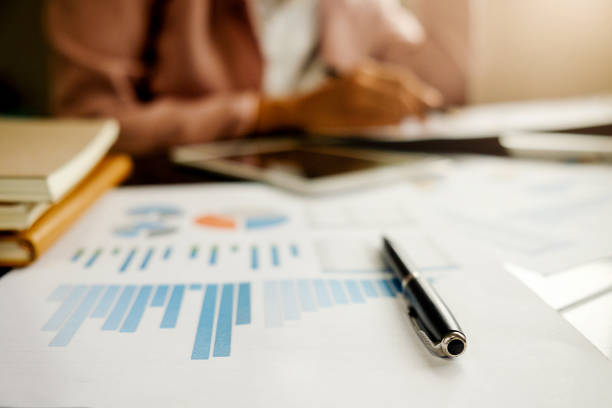 istock Business concept with copy space. Office desk table with glasses focus and analysis chart computer notebook cup of coffee on desk.Vintage tone Retro filter effect.Selective focus. 800309594