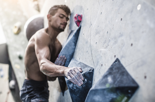 Athlete Climbing in a Bouldering Gym