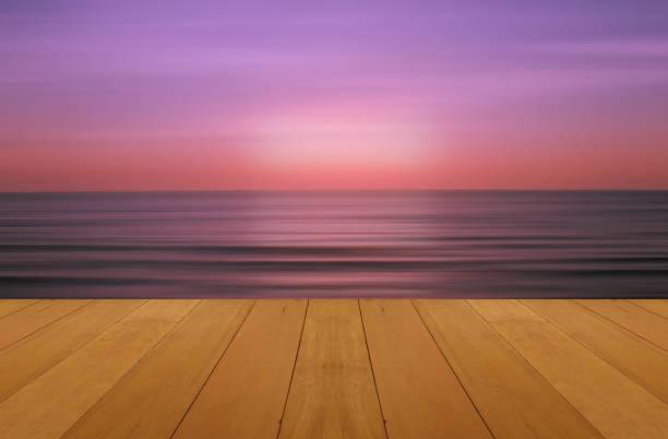 plancher de bois sur mer avec purple coucher de soleil brûlant skie belle naturelle mer tropicale - water wave sea tranquil scene photos et images de collection