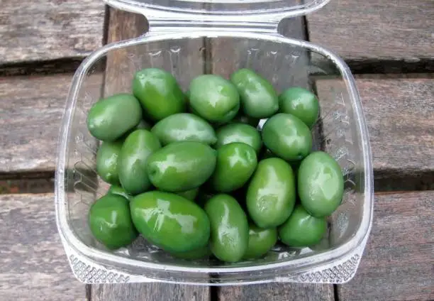 Large cerignola green olives in a plastic container