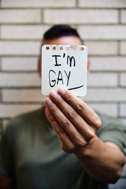 istock young man with a note with the text I am gay 800324586