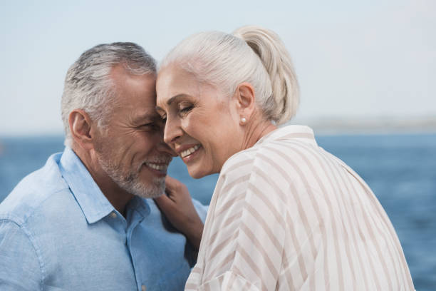 istock casual grey haired couple smiling and embracing at quay 800337442