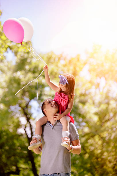 istock Father carrying his daughter on shoulders 800338046