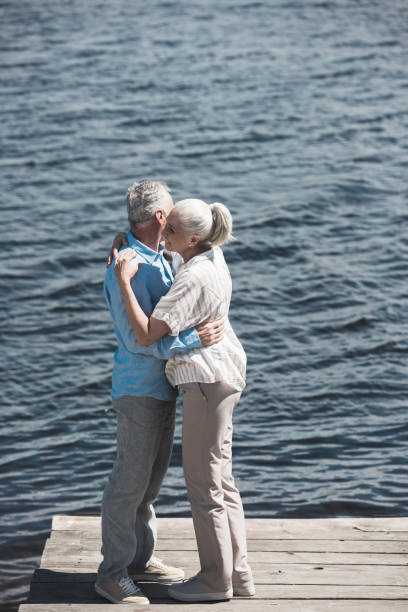 istock casual grey haired couple hugging on riverside at daytime 800341536
