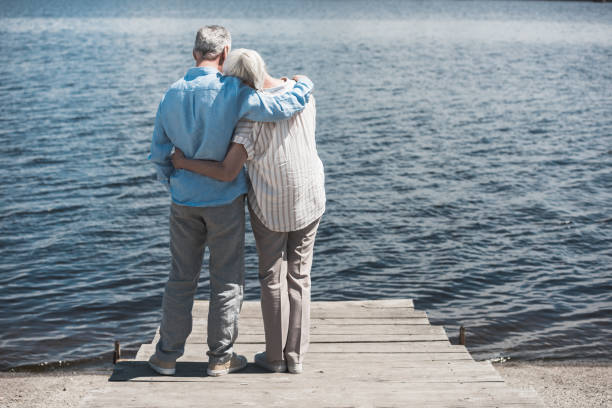 istock back view of senior couple embracing while standing on riverside at daytime 800349128