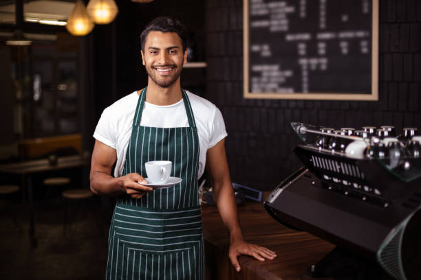 istock Smiling barista holding a cup of coffee 800355082