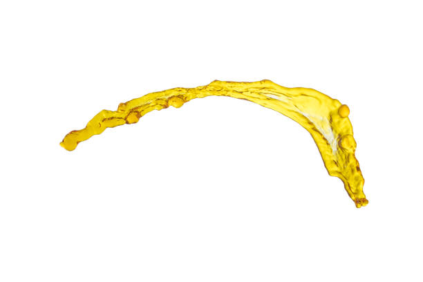 istock beautiful yellow liquid splash isolated over white background and many drops 800355594