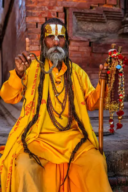 In Hinduism, sadhu, or shadhu is a common term for a mystic, an ascetic, practitioner of yoga (yogi) and/or wandering monks. The sadhu is solely dedicated to achieving the fourth and final Hindu goal of life, moksha (liberation), through meditation and contemplation of Brahman. Sadhus often wear ochre-colored clothing, symbolizing renunciation.