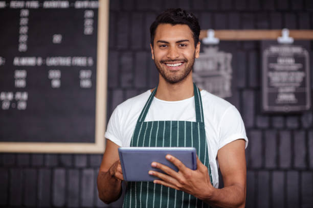 istock Smiling barista using tablet and looking at the camera 800369256
