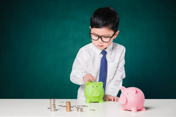 istock Cute business boy with a stack of coins 800375644