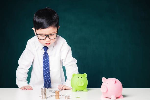 istock Cute business boy with a stack of coins 800375650