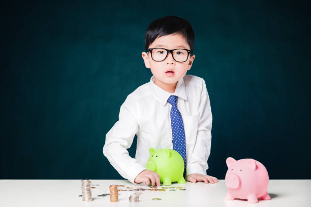 istock Cute business boy with a stack of coins 800375654