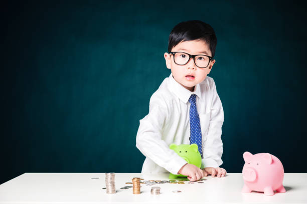 istock Cute business boy with a stack of coins 800375656