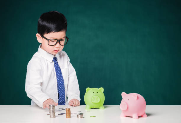istock Cute business boy with a stack of coins 800375660