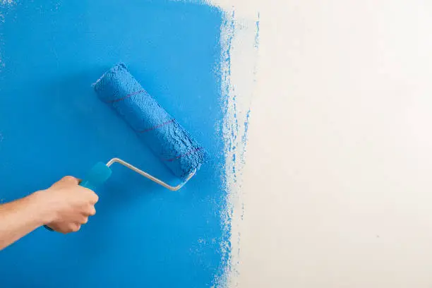 Close-up , the painter paint the wall of the room.