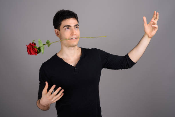 Studio shot of young handsome man against gray background