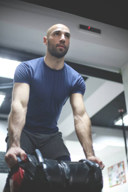 istock Workout time. Man holding a weight in the gym. 800390668