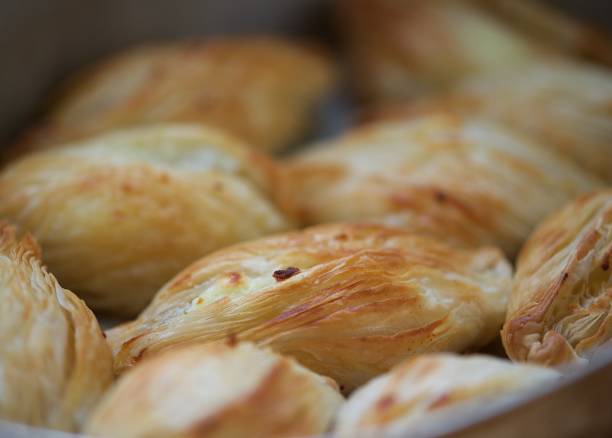 maltees bakken delicatesse, pastizzi. pastizzi, typische straatvoedsel. maltees pasta met ricotta en erwtjes. maltees voedsel. foto uit de top. maltees pastizzi - maltese eilanden stockfoto's en -beelden