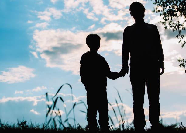 istock silhouette of father and son holding hands at sunset 800394854