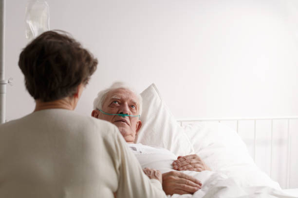 istock Wife sitting by dying husband 800394954