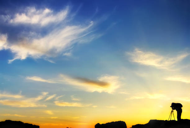 istock Silhouette of a photographer with backpack with a beautiful sunset 800395732