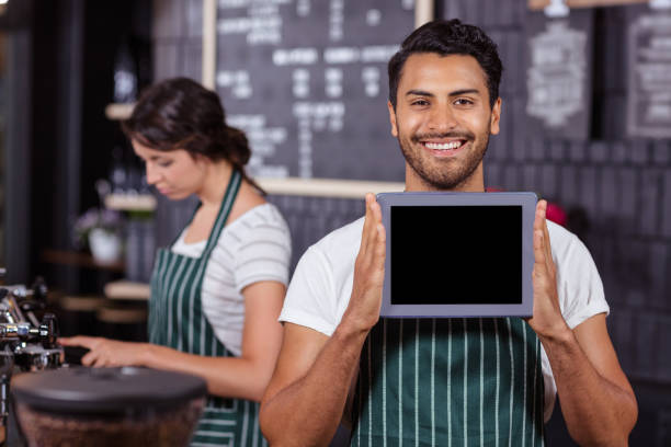 istock Smiling barista showing tablet at the camera 800402000