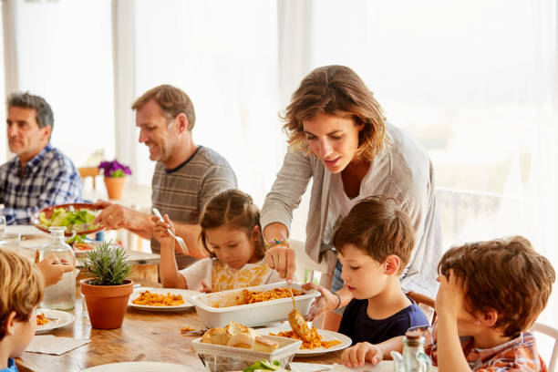 mãe, servindo de alimento para crianças contra a janela - family meal - fotografias e filmes do acervo