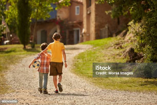 Rear View Of Siblings Walking On Pathway Stock Photo - Download Image Now - Brother, Child, Walking