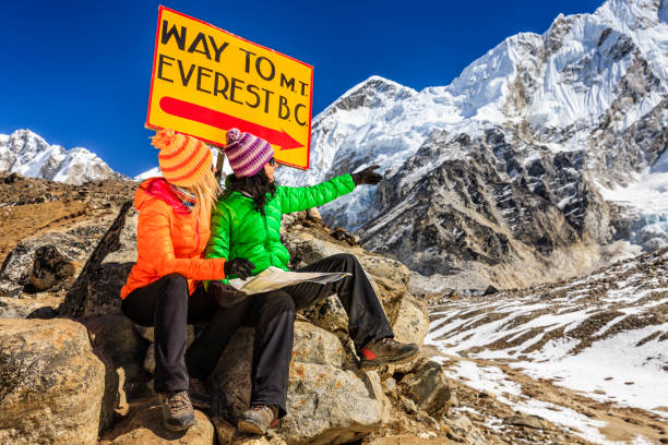 istock Young women studying map next to signpost, Nepali Himalaya 800420724