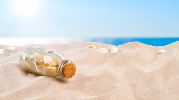 istock On the Beach - bottle which is containing a collection of shells, placed on a sand dune in front of beautiful azure sea 800426152