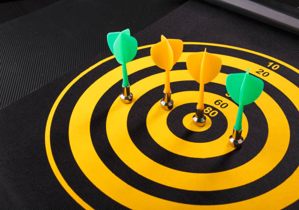 Magnetic dart arrows on yellow dart board. black background