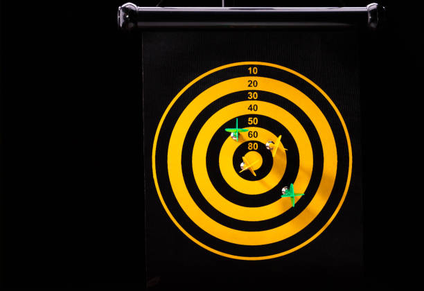 Magnetic dart arrows on yellow dart board. black background