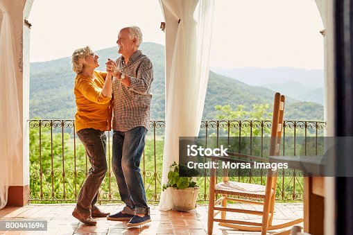 istock Loving senior couple dancing in balcony at home 800441694