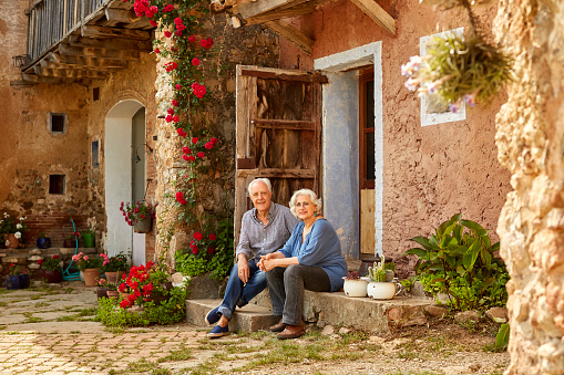 Portrait of smiling senior couple sitting on porch