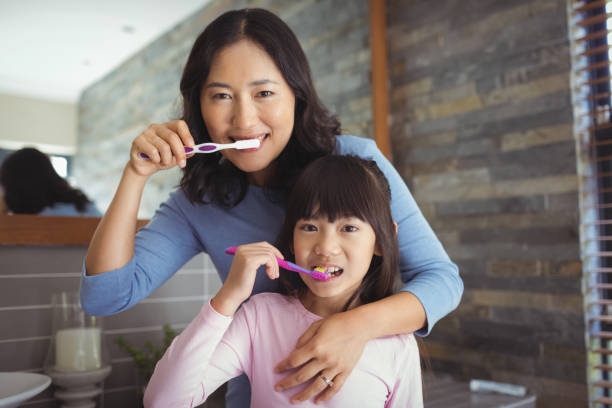 istock Mother and daughter brushing teeth in the bathroom 800442012