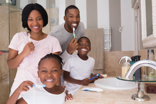 glückliche familie zähneputzen im bad zu hause - child brushing human teeth brushing teeth stock-fotos und bilder