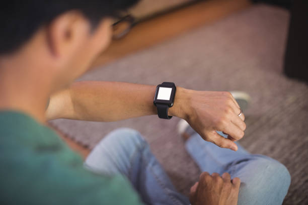 istock Man using smart watch in living room 800445210