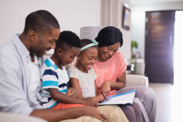 istock Smiling family reading magazine while sitting on sofa 800448040