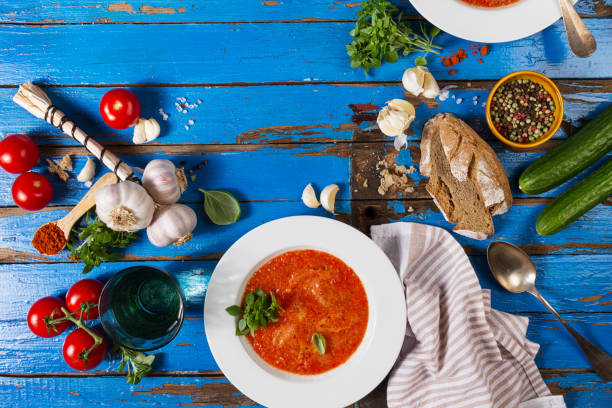 istock Tasty appetizing classic spanish soup gazpacho in white plates on rustic blue table with bread, garlic and spices. Dinner Food Concept. Top View. 800457078