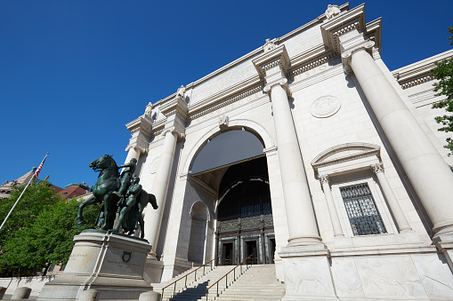 New York - September 13, 2016: American Museum of Natural History building facade with Theodore Roosevelt statue in a sunny day, blue sky. This is one of the largest museum of natural history of the world.