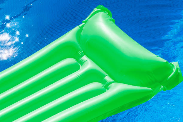 istock Green air mattress floating in a swimming pool. 800461928