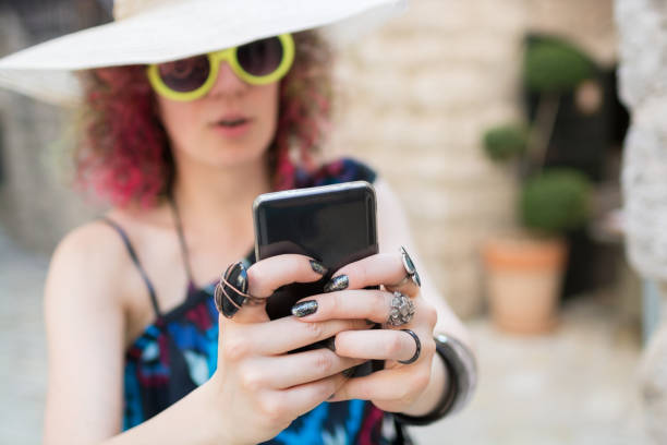 istock Female with sunhat using smart phone in coastal old town 800464836