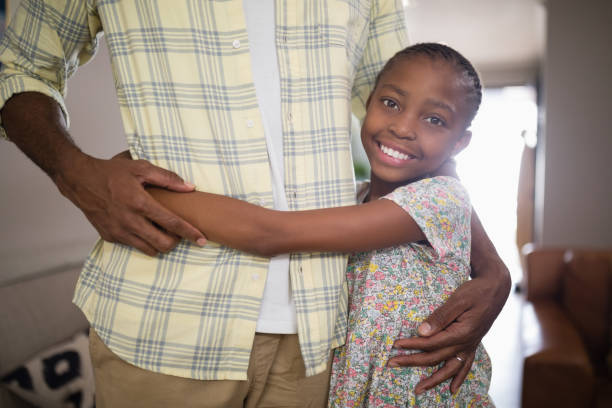 istock Smiling girl embracing father at home 800473098