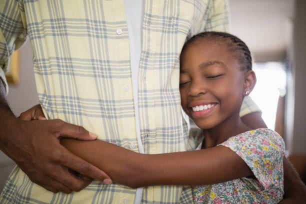 istock Mid section of man embracing smiling daughter 800473182