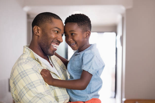 istock Father and son looking at each other in living room 800476262